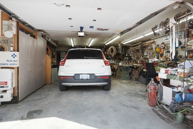 inside of a garage with shelving containing various items and a white car